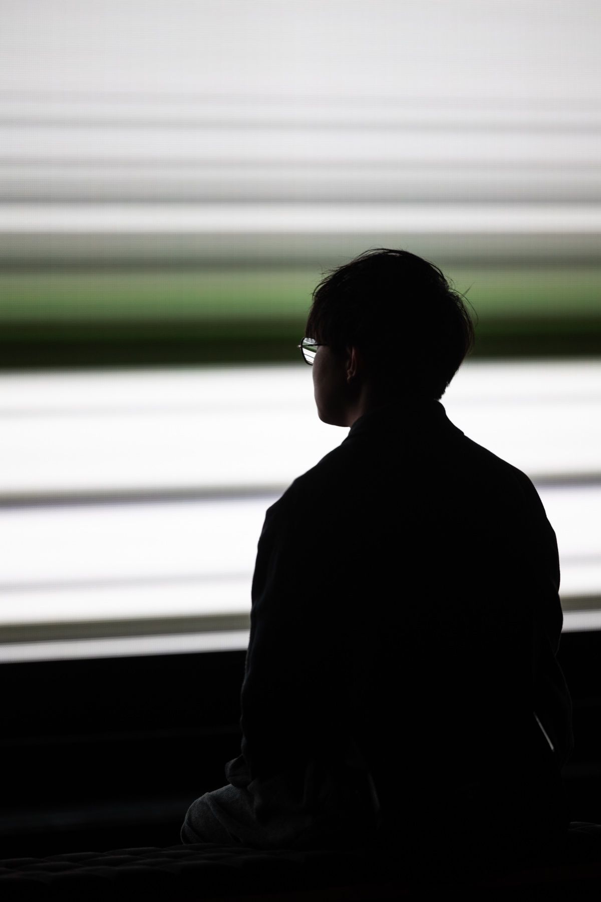 A man in silhouette against a passing train