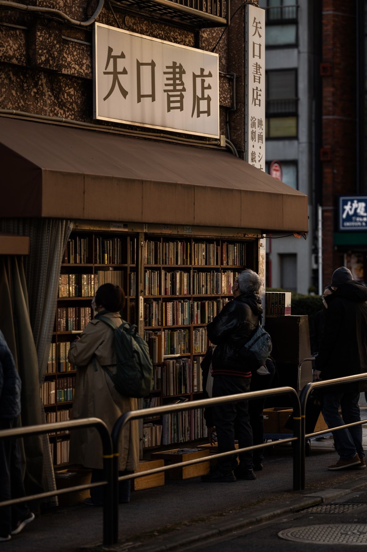 A street-corner bookshop in Tokyo, books stacked on the pavement