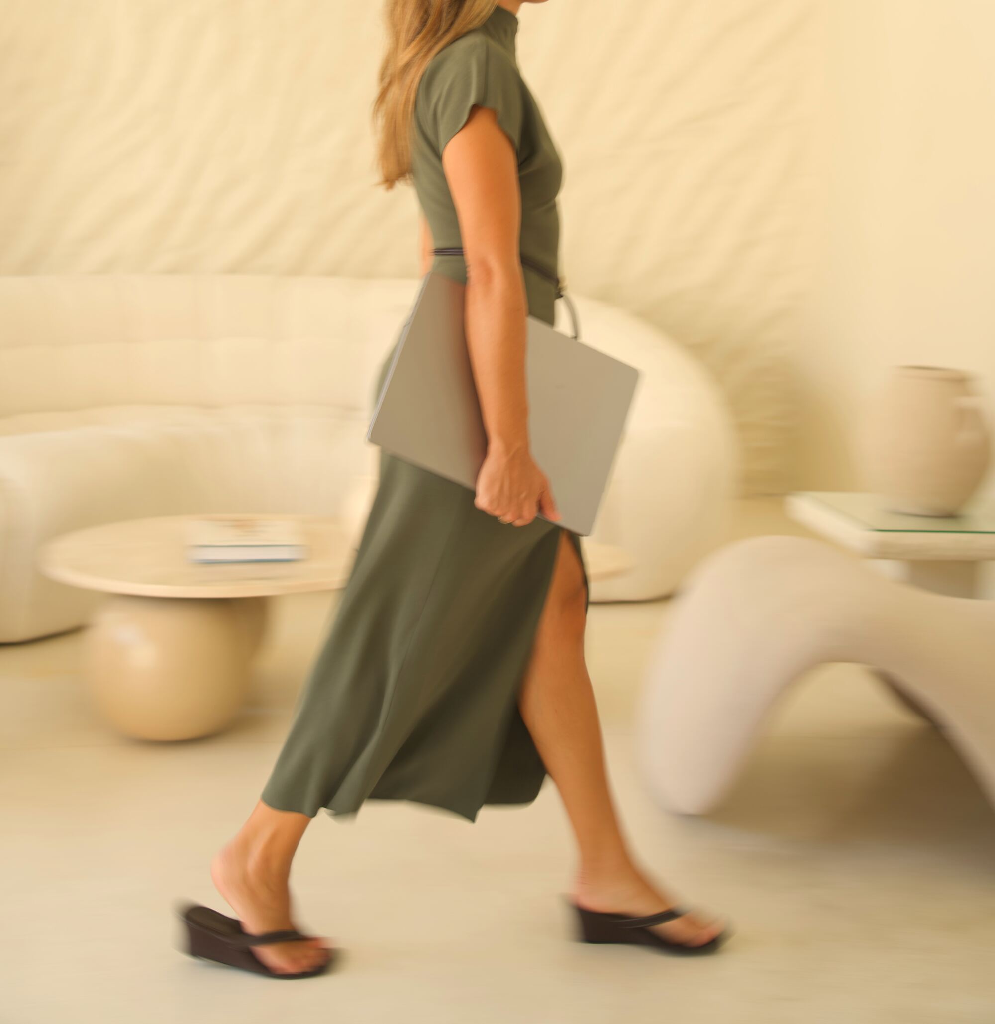 Chiara Colella walking through the studio with her laptop
