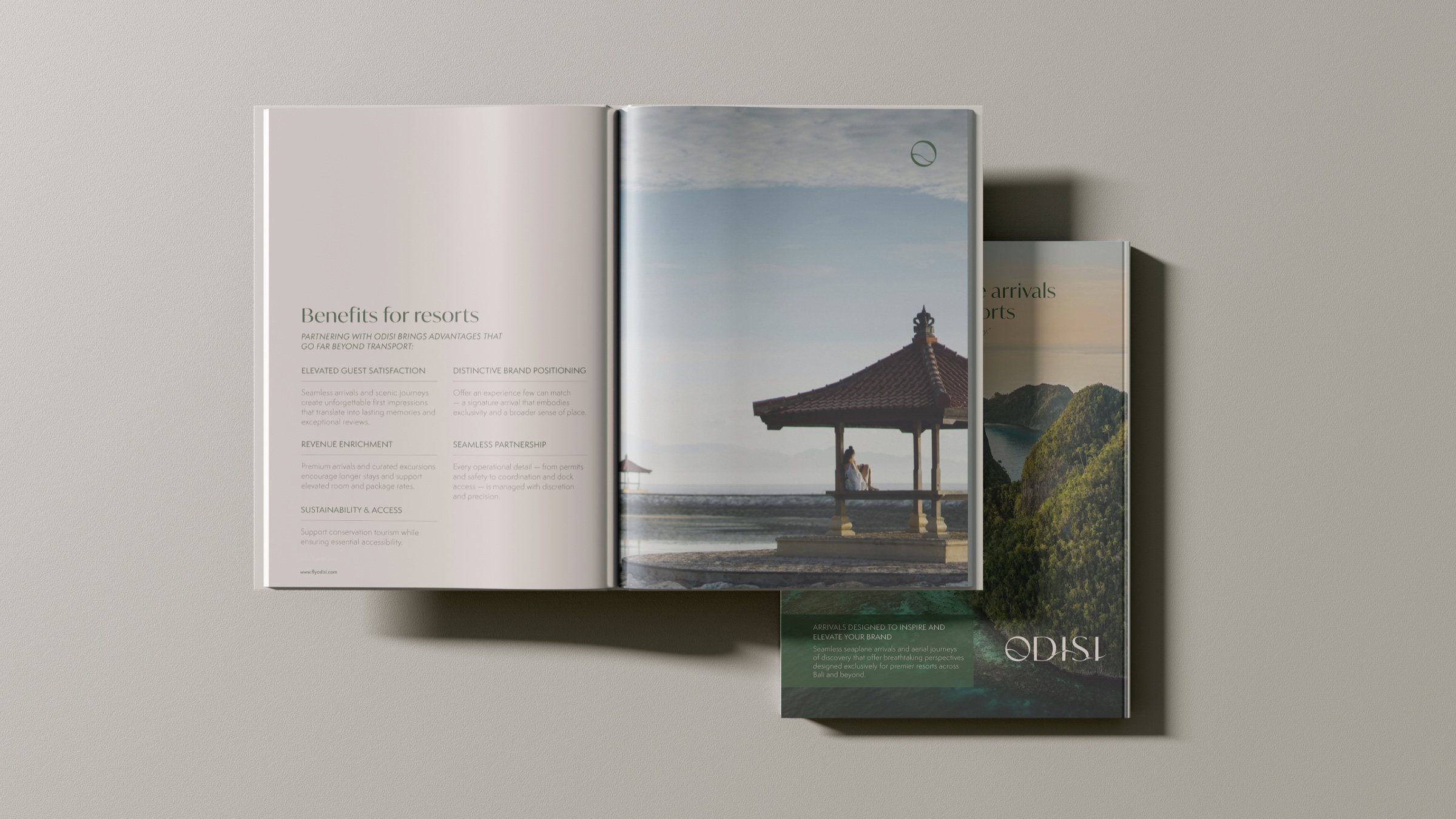 The Odisi resort brochure, open on a spread with the cover beside it