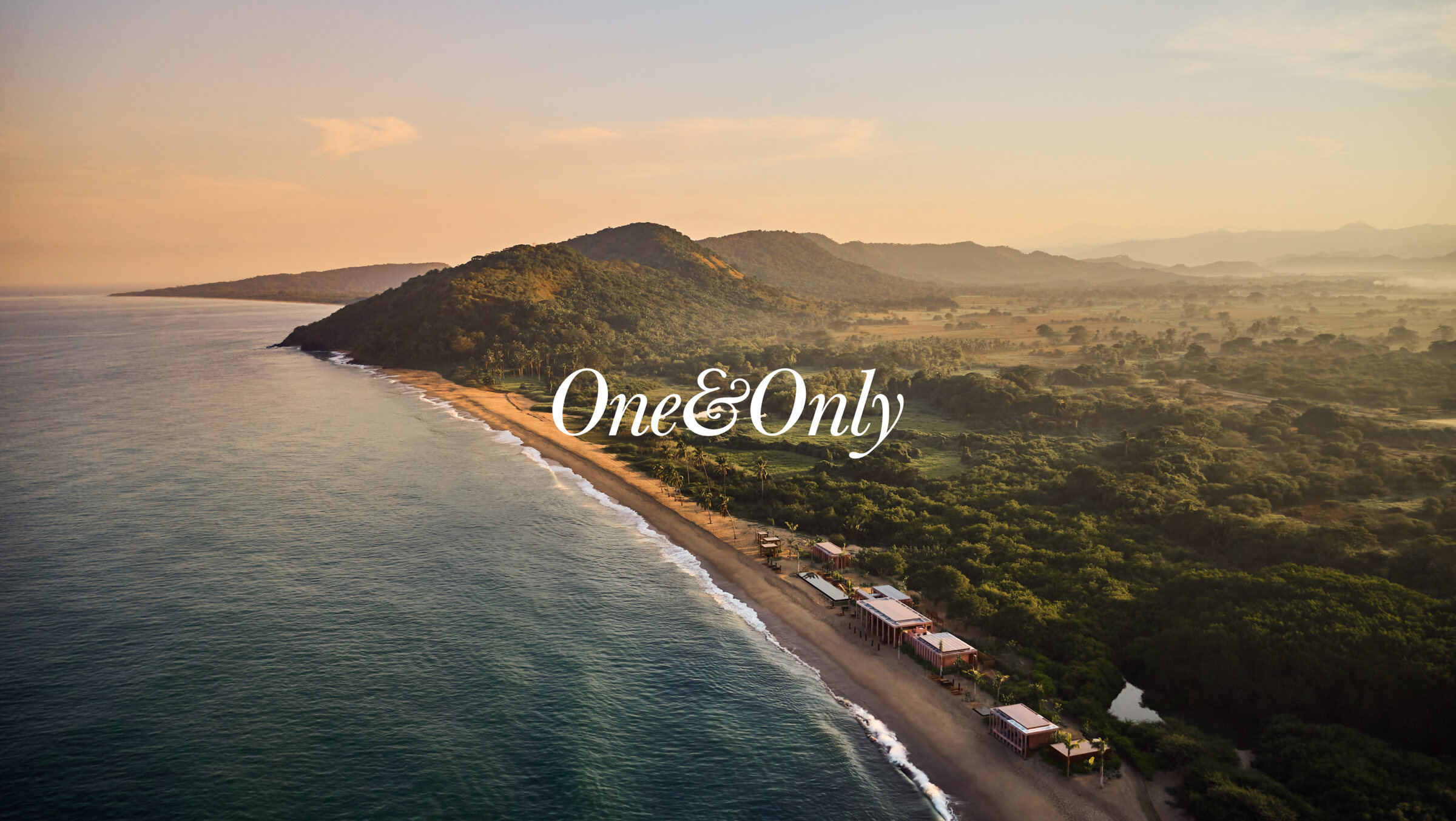 The Mandarina coast at dawn with the One&Only wordmark set over it