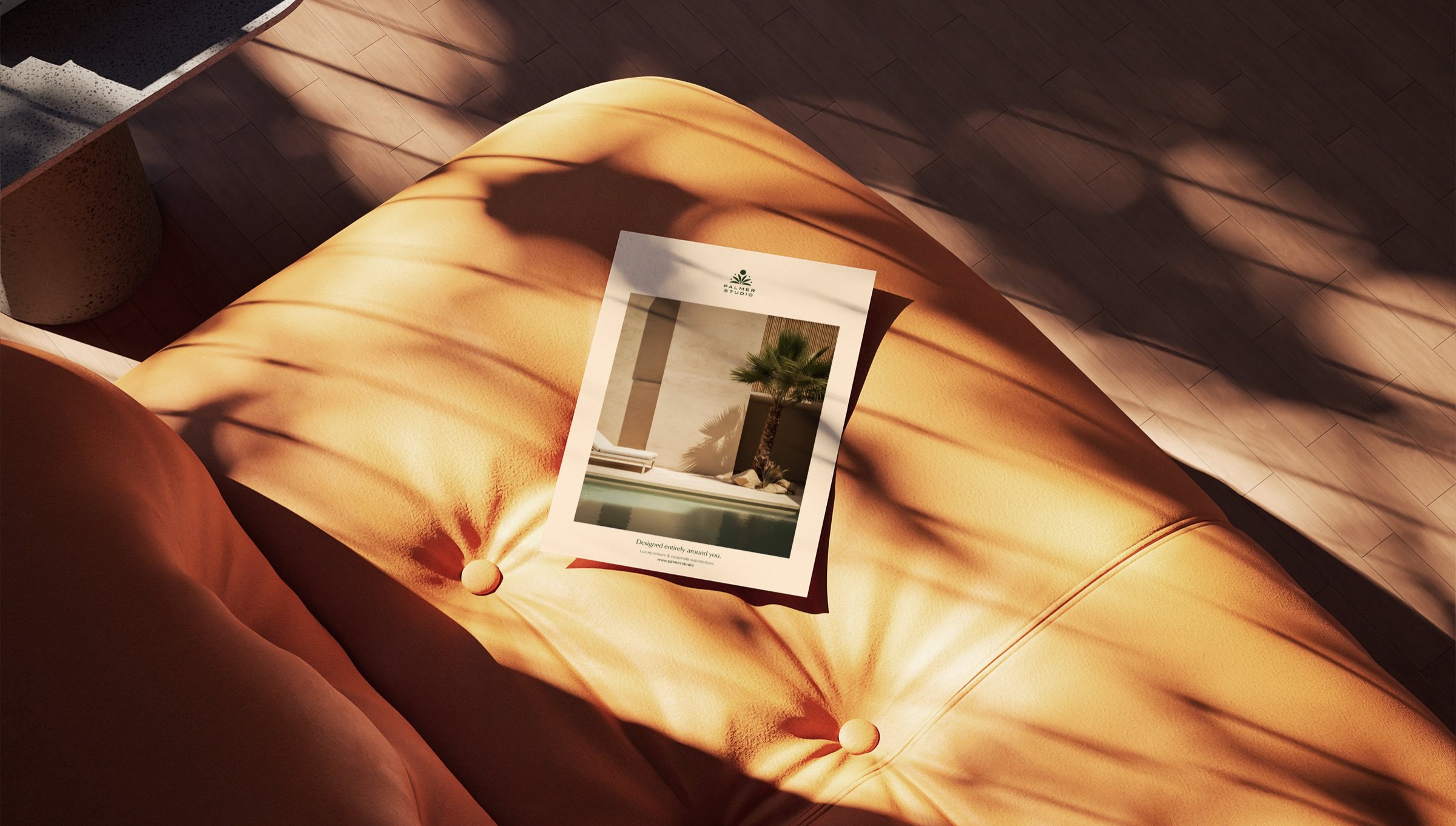 A Palmer Studio print piece – 'Designed entirely around you' – on a leather sofa in sunlight