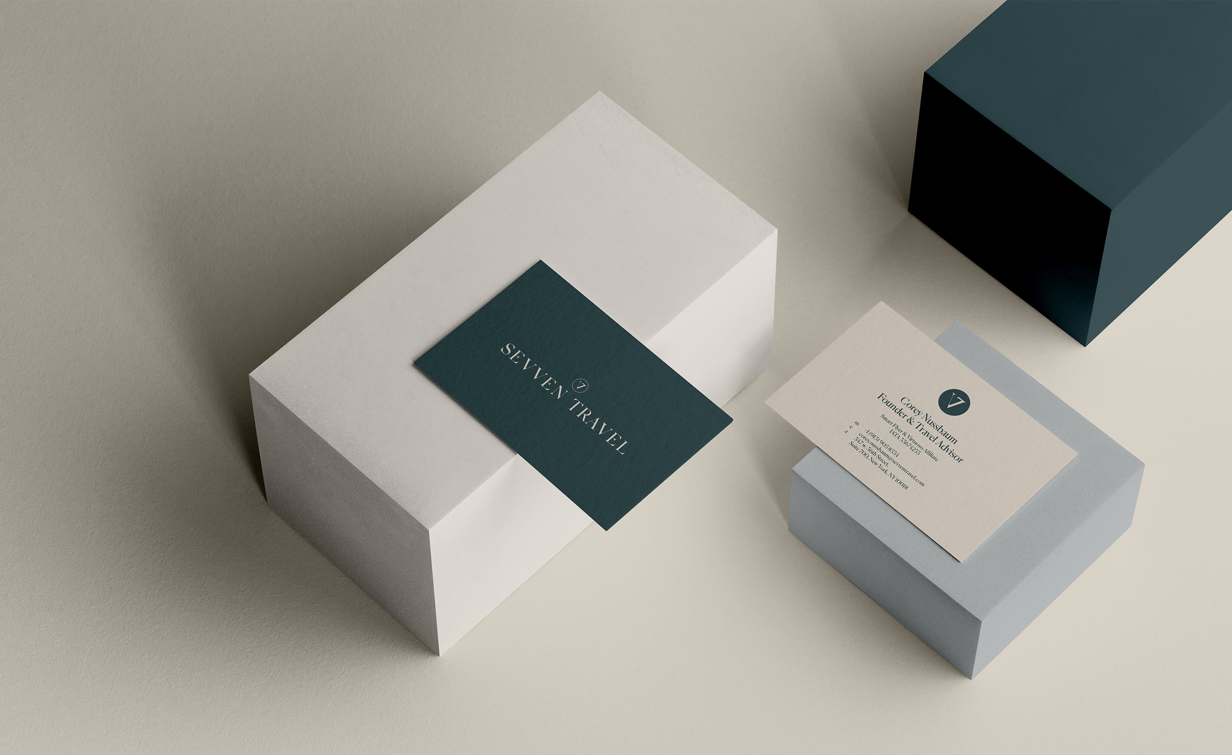 Sevven Travel business cards in deep teal and stone