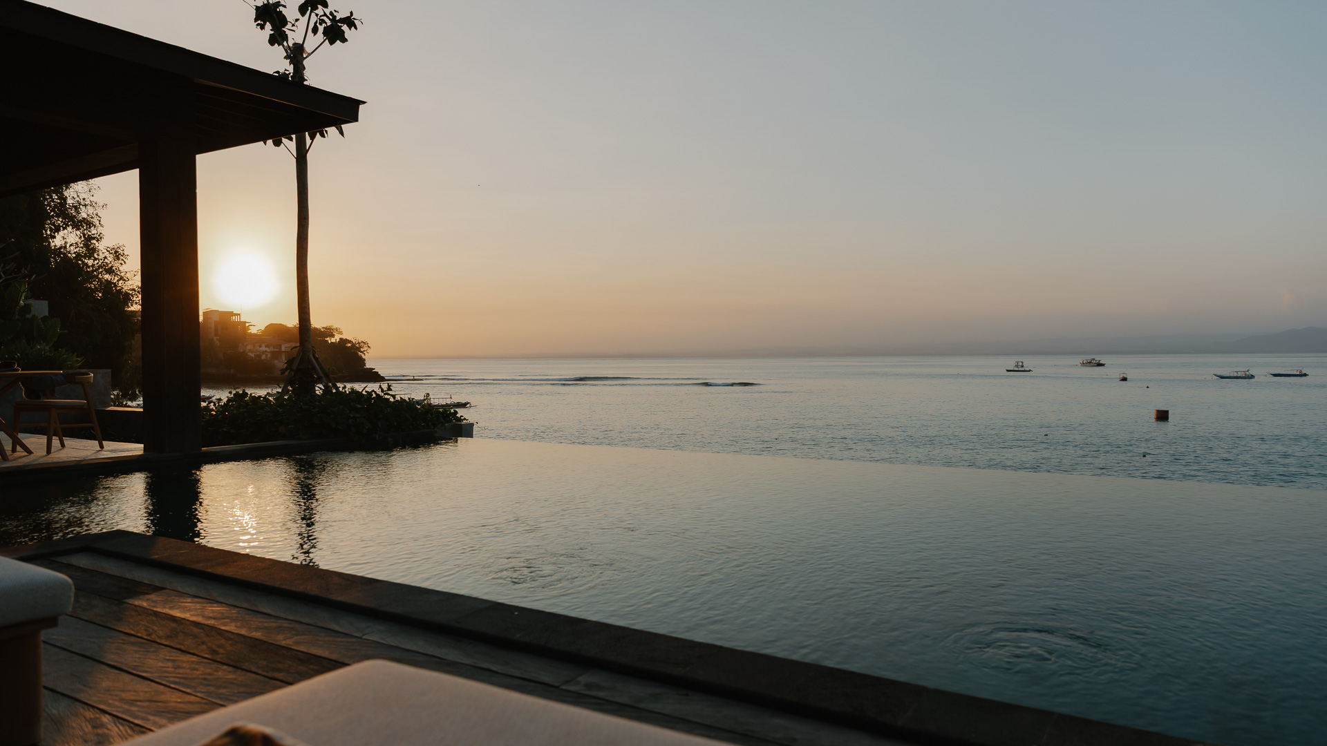 The infinity pool at sunrise, the sea beyond